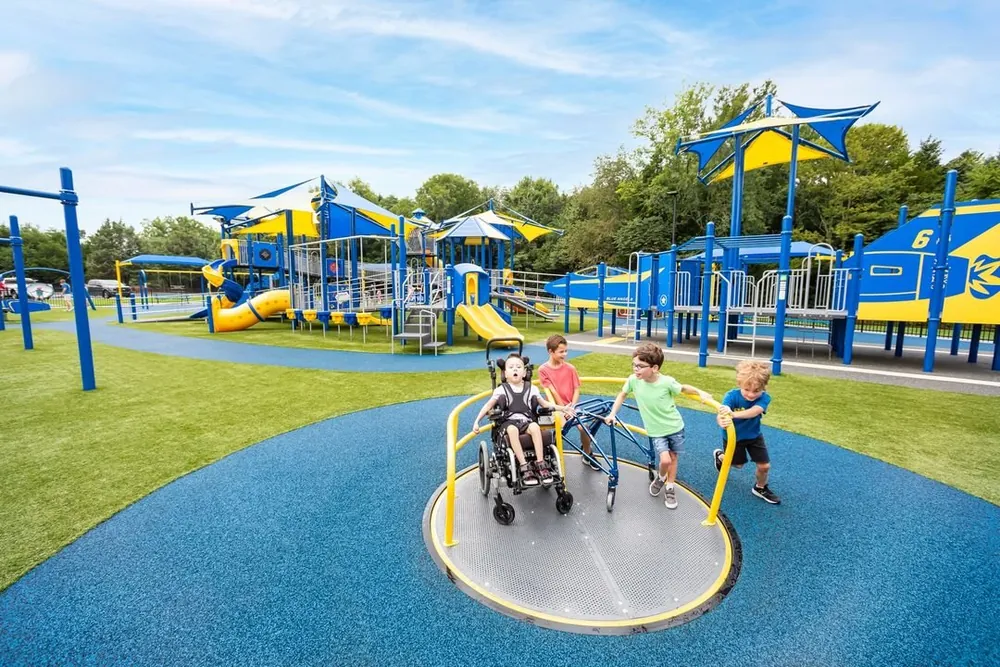 Children climbing rock features under green shade sails