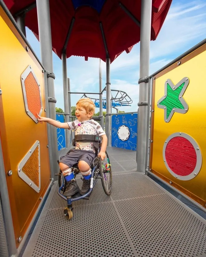 Child playing on an accessible ground level play panel