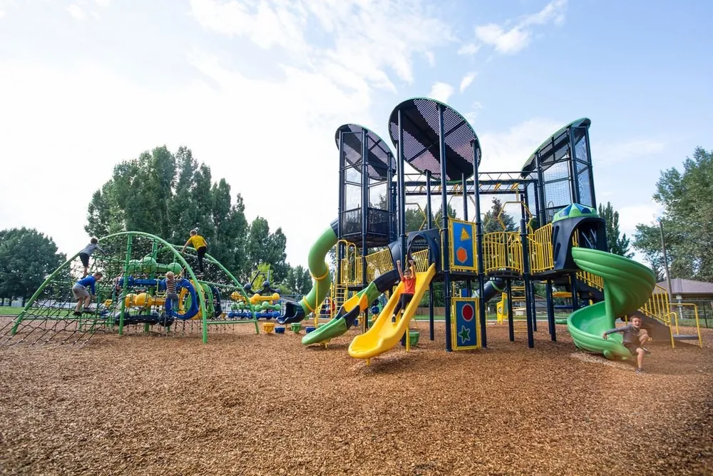 Large multi level play structure with slides in a community park